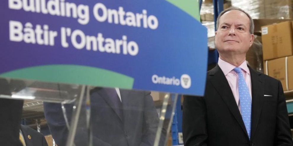 Ontario Finance Minister Peter Bethlenfalvy listens to Ontario Premier Doug Ford speak after touring the Oakville Stamping and Bending Limited facility in Oakville, Ont., on Wednesday, March 22, 2023. THE CANADIAN PRESS/Nathan Denette