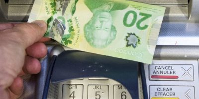 Money is removed from an ATM in Montreal, Monday, May 30, 2016.