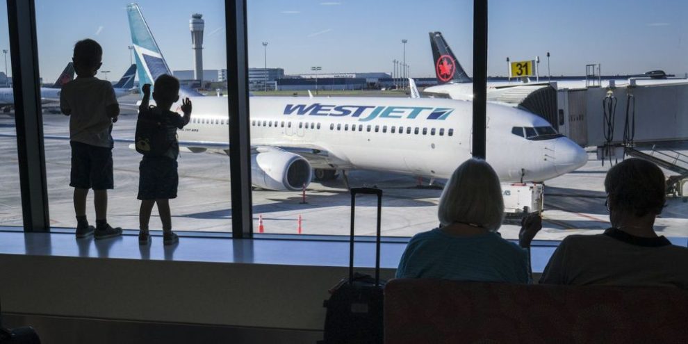 Young boys look out at Air Canada and WestJet planes at Calgary International Airport in Calgary on August 31, 2022. THE CANADIAN PRESS/Jeff McIntosh