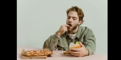 eating pizza fast food via pexels by Ron Lach