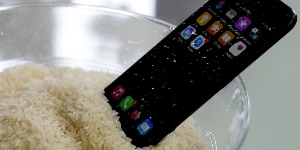 A view of a wet smartphone placed in a bowl of rice to dry