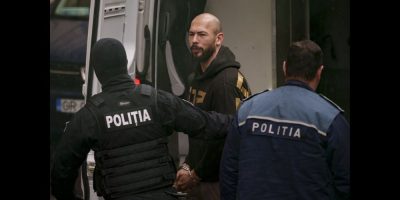 Police officers escort Andrew Tate, center, handcuffed, to the Court of Appeal in Bucharest, Romania, Tuesday, March 12, 2024. Online influencer Andrew Tate was detained in Romania and handed an arrest warrant issued by British authorities, his spokesperson said Tuesday. (AP Photo/Andreea Alexandru)