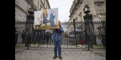 Artist Kaya Mar holds his painting of Britain's Prince and Princess of Wales outside Downing Street in London, Wednesday, March 20, 2024. A British privacy watchdog is looking into a report that staff at a private London hospital tried to snoop on the Princess of Wales' medical records while she was a patient for abdominal surgery. The Information Commissioner's Office said: "We can confirm that we have received a breach report and are assessing the information provided." (AP Photo/Kirsty Wigglesworth)