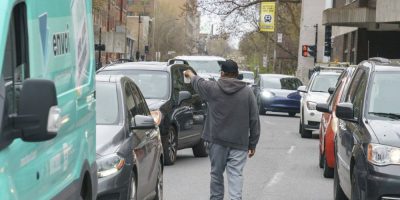 A homeless native man panhandles between cars stopped at a red light in Montreal on Wednesday, May 4, 2022. An Ontario court has struck down sections of the province's panhandling law as unconstitutional. THE CANADIAN PRESS/Paul Chiasson