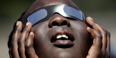 In this photo taken Friday, Aug. 18, 2017, Poureal Long, a fourth grader at Clardy Elementary School in Kansas City, Mo., practices the proper use of eclipse glasses in anticipation of Monday's solar eclipse.