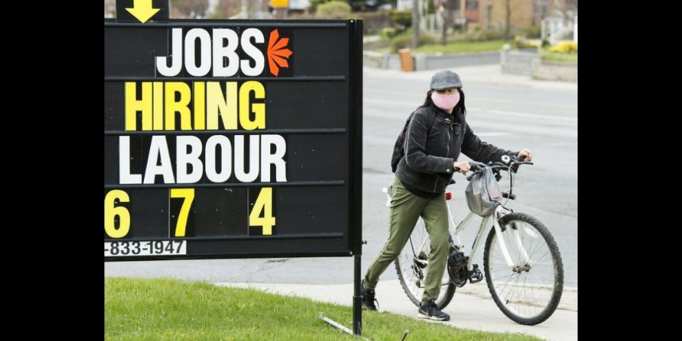 Statistics Canada says the economy added 41,000 jobs in February, following a similar gain in employment the previous month. A cyclist moves past a jobs advertisement sign in Toronto on Wednesday, April 29, 2020. THE CANADIAN PRESS/Nathan Denette