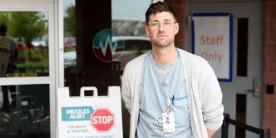 Doctor stands in front of hospital entrance - CP