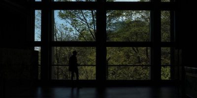 A visitor walks past a window that offers a view of the ravine at the Ontario Science Centre, in Toronto, Friday, May 5, 2023.