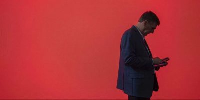 man looks at smartphone - AP