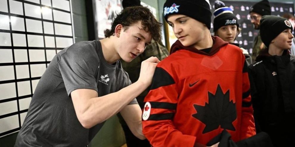 Matthew Schaefer (left) signs a Canadian hockey fan's jersey after practice in Petawawa, Ont.