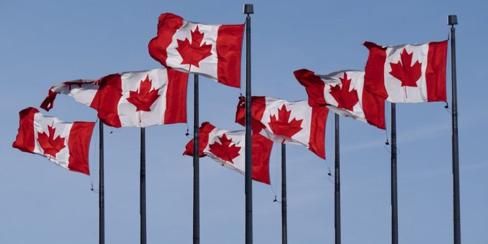 Canadian flags are seen flying behind the National Archives building in Ottawa