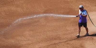 Coors Field head groundskeeper Mark Razum wets down the skin of the infield for a baseball game