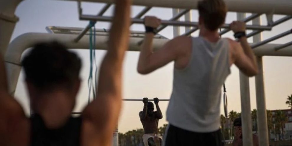 People work out in an open-air gym next to the beach in Barcelona.
