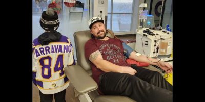 A man sitting in a chair, donating blood.