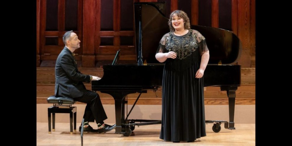 A male pianist accompanied by a female opera singer.