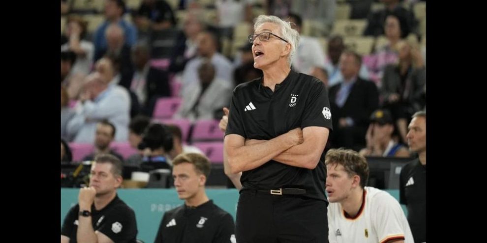 Gordie Hebert standing in front of the German men's national basketball team's bench during a gam in the 2024 Olympic Men's Basketball Tournament