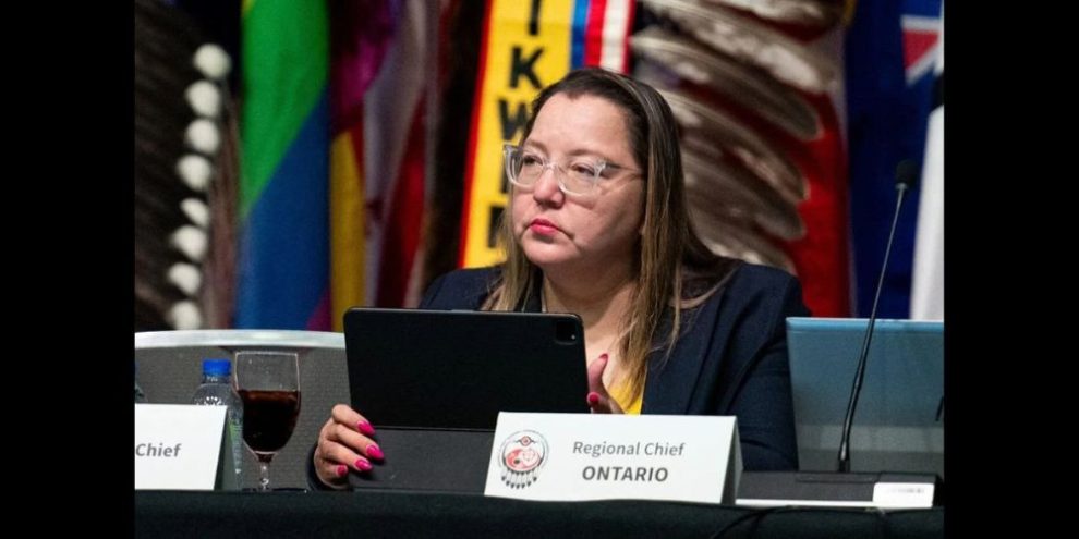 A woman sits at a press podium.