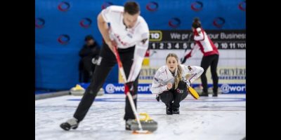 Brett Gallant sweeping a stone thrown by his wife, Jocelyn Peterman
