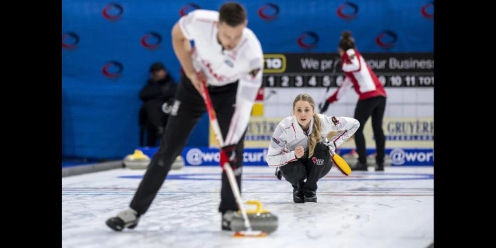Brett Gallant sweeping a stone thrown by his wife, Jocelyn Peterman