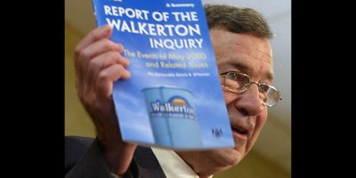 Dennis O'Connor with a copy of the summary of the "Report of the Walkerton Inquiry"