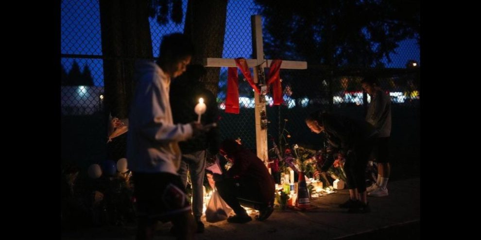 Families mourning at a candle-lit vigil