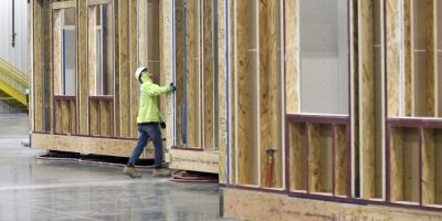 Construction worker looking at house frame.