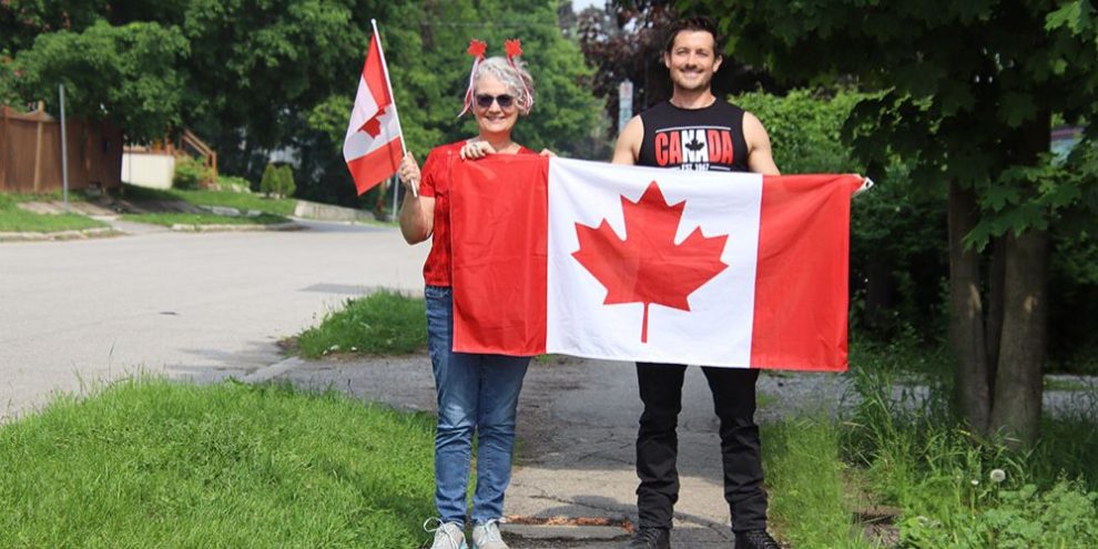 Orillia councillors Janet-Lynne Durford (left) and Luke Leatherdale (right) waving Canadian flags