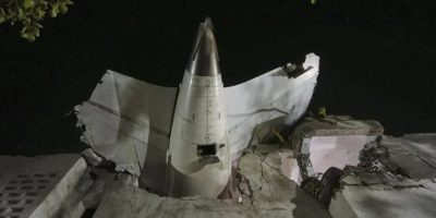 The tail of the airplane is seen stuck in a building at the site of an airplane that crashed in India's northwestern city of Ahmedabad in Gujarat state