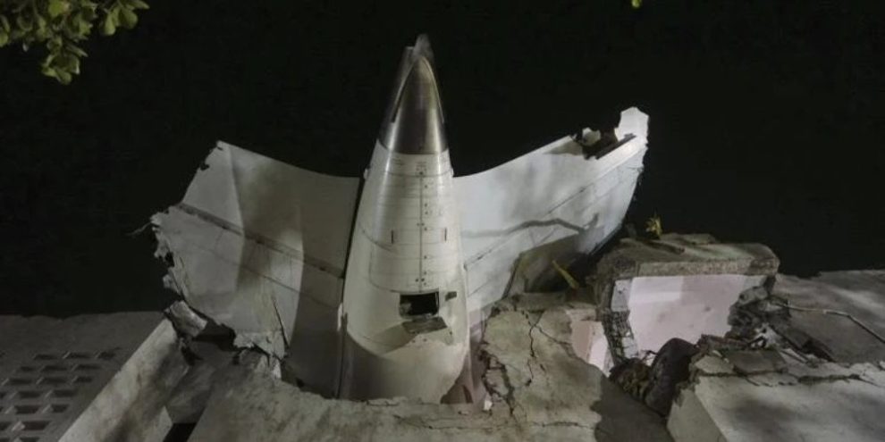 The tail of the airplane is seen stuck in a building at the site of an airplane that crashed in India's northwestern city of Ahmedabad in Gujarat state