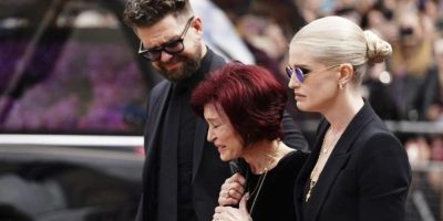 The family of Ozzy Osbourne from left, Jack Osbourne, Sharon Osbourne and Kelly Osbourne lay flowers and view the flowers left at the Black Sabbath Bridge bench on Broad Street in memory of Black Sabbath frontman Ozzy Osbourne ahead of the funeral procession, in Birmingham, England