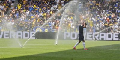 Auckland City's Gerard Garriga cools off under the sprinklers during a water break in the Club World Cup Group C soccer match between Auckland City and Boca Juniors in Nashville, Tenn.