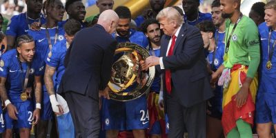 U.S. President Donald Trump, centre right, and FIFA president Gianni Infantino, centre left, hand Chelsea's Reece James (24) the championship trophy following the Club World Cup final soccer match between Chelsea and PSG at MetLife Stadium in East Rutherford, N.J.