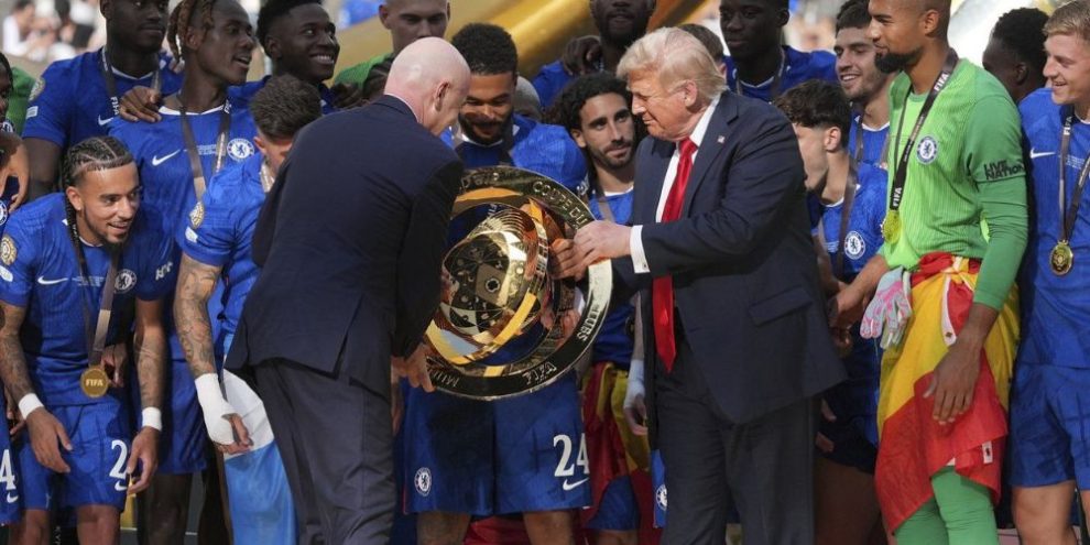 U.S. President Donald Trump, centre right, and FIFA president Gianni Infantino, centre left, hand Chelsea's Reece James (24) the championship trophy following the Club World Cup final soccer match between Chelsea and PSG at MetLife Stadium in East Rutherford, N.J.