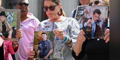 A woman holds a photo outside a Los Angeles courthouse after a jury ruled Meta and YouTube liable in a landmark social media addiction trial.
