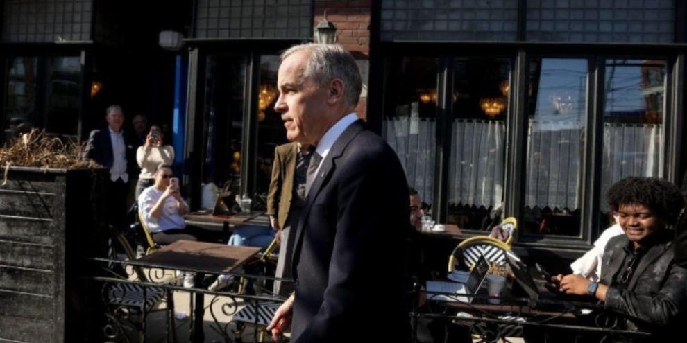 Prime Minister Mark Carney walking through a Toronto neighbourhood on March 30, 2026, during a visit to a local business ahead of unveiling Canada’s nature conservation strategy.