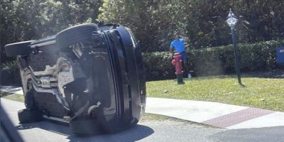 Tiger Woods standing beside his overturned vehicle on Jupiter Island, Florida, after a crash on March 27, 2026.