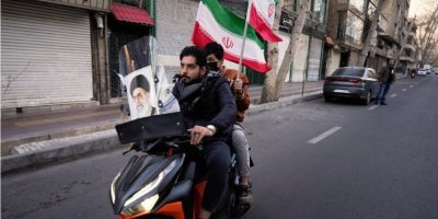 Motorcyclists pass a mural of the late Iranian leader Ali Khamenei near his residence in Tehran following his reported death in U.S. and Israeli strikes.