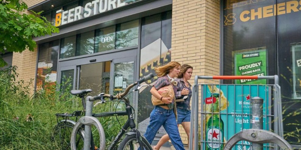 Pedestrians walk past a Beer Store on Gerrard Street in Toronto’s east end, scheduled to close in fall 2025.