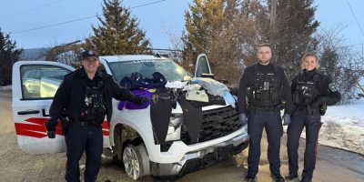 South Simcoe Police stand beside a stolen U-Haul pickup truck seized in Bond Head, along with recovered stolen clothing and suspected drugs.