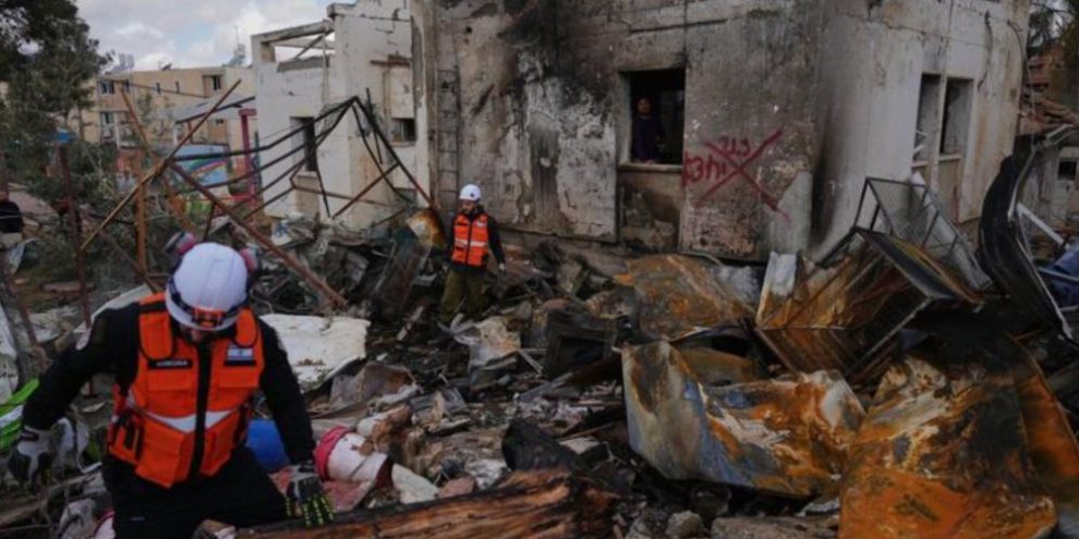 Israeli security forces inspect damage at a missile strike site in Dimona, southern Israel, caused by an Iranian missile, March 22, 2026.