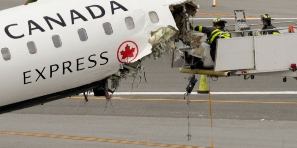 Airport firefighters clear debris from the wreckage of an Air Canada Express jet following a runway collision at LaGuardia Airport in New York.
