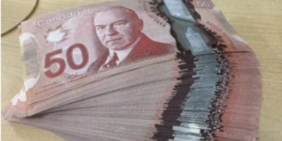 Canadian $50 bills arranged on a surface, illustrating the type of currency used in a recent Barrie counterfeit cash scam.