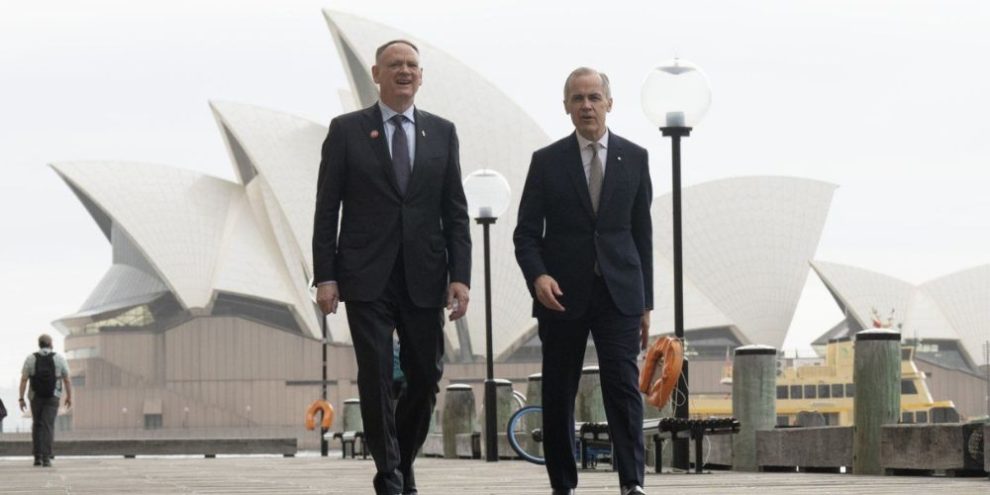 Prime Minister Mark Carney and Defence Minister David McGuinty walk to a news conference in Sydney, Australia, on March 4, 2026.