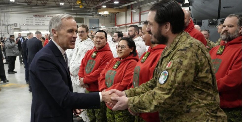 Prime Minister Mark Carney shakes hands with Canadian Armed Forces members after announcing $32 billion for Arctic defence and northern infrastructure in Yellowknife.