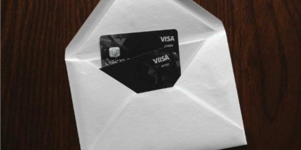 Two Visa credit cards placed beside a sealed envelope in a fraud prevention image from Barrie Police Service