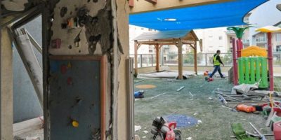 A man walks through a damaged kindergarten courtyard in Rishon LeZion after an Iranian missile strike during escalating conflict between Israel and Iran on March 21, 2026.
