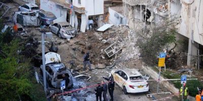 Israeli security and rescue crews respond to damage at the scene of an Iranian missile strike in central Tel Aviv.