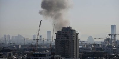 Smoke rising over Tel Aviv after an Iranian missile strike as tensions escalate between Iran, Israel, and the United States