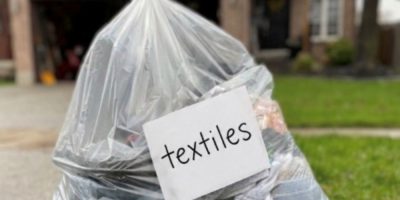 Bag of donated clothing and textiles set out at the curb in Barrie, Ontario during Textile Collection Week.