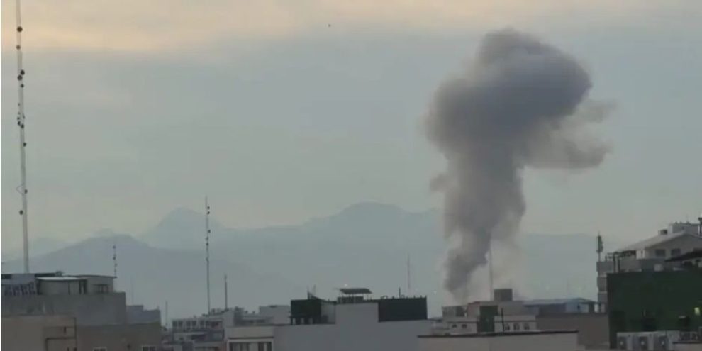 Airstrike damage in Tehran with smoke rising over buildings